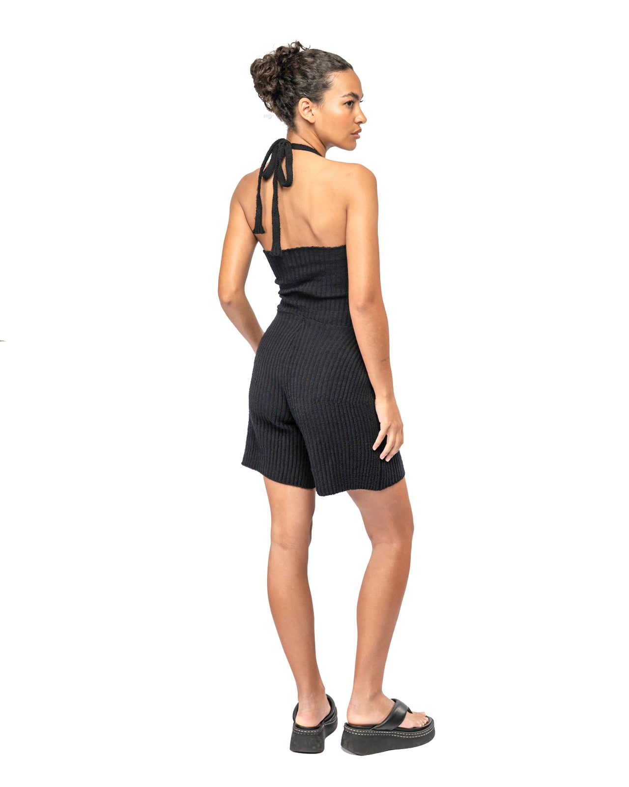 Woman wearing a black ribbed halter and short set on a white background