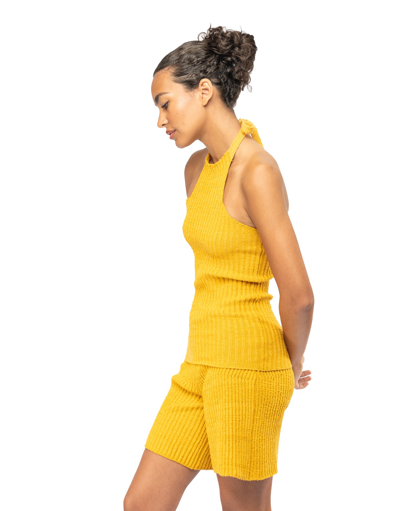 Woman wearing a yellow knit set on a white background
