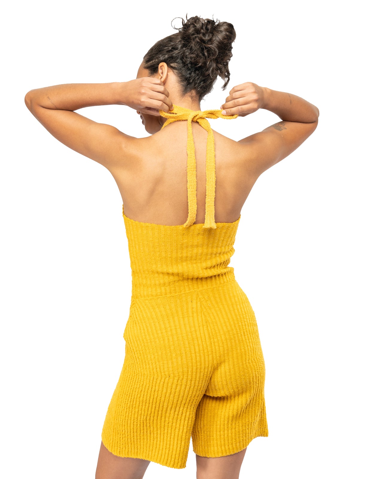 Woman wearing a yellow ribbed knit set on a white background