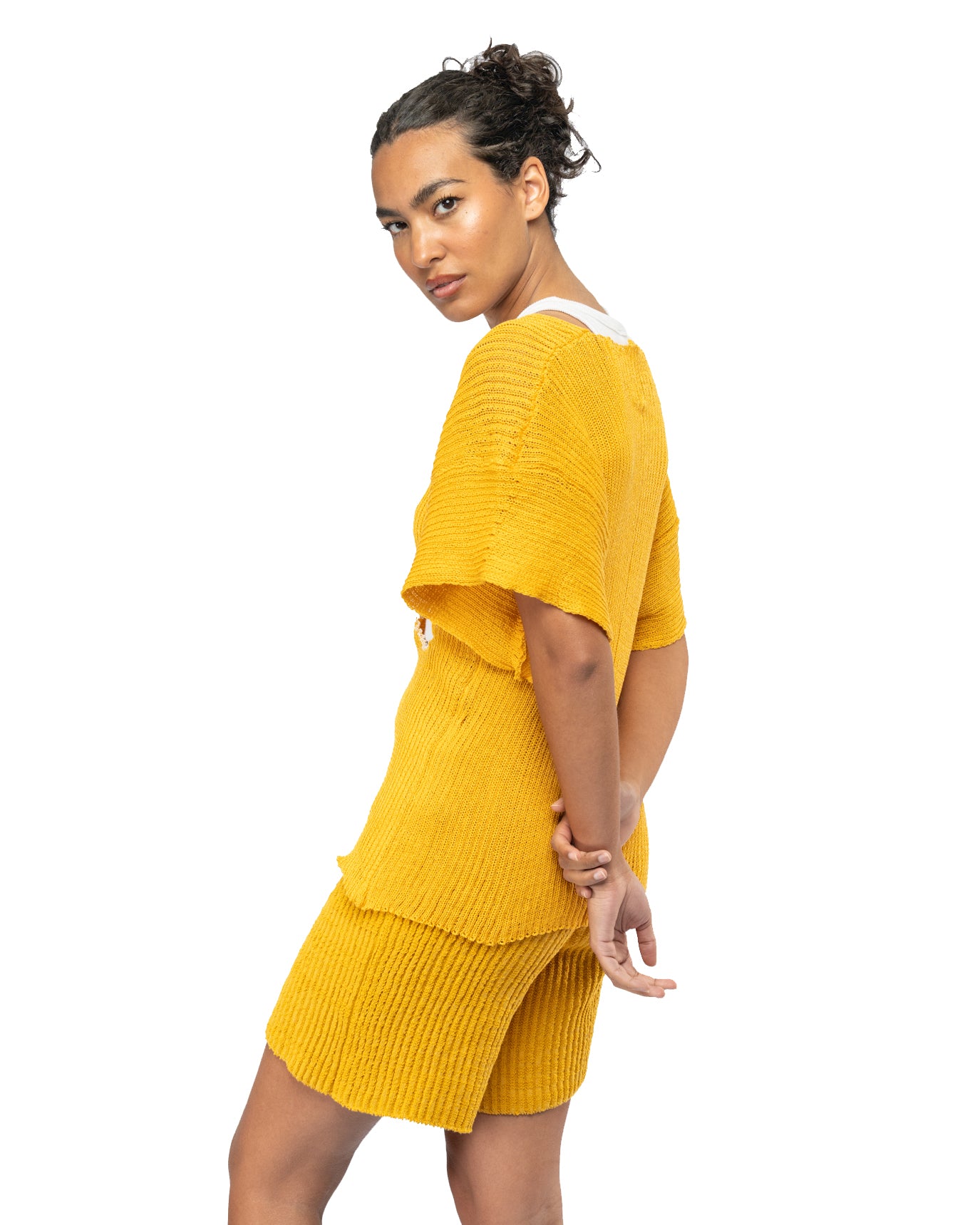 Woman wearing a yellow knitted outfit on a white background